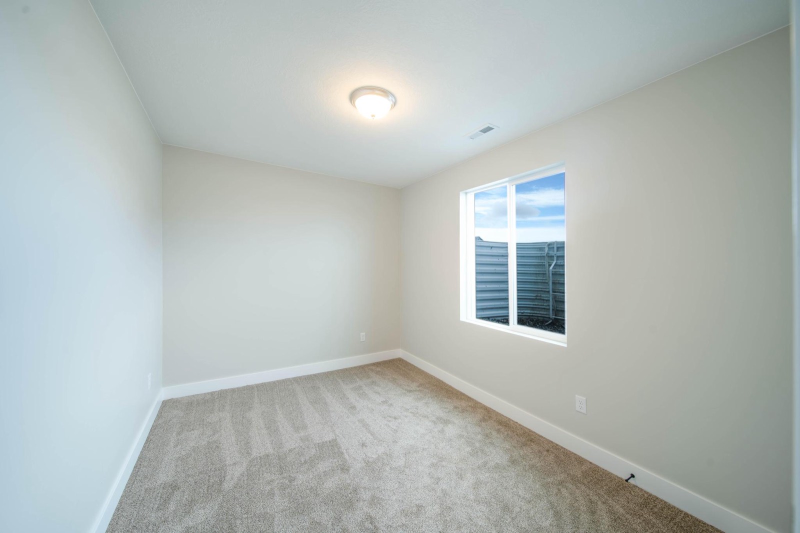 Finished basement apartment room with clean trim and carpet