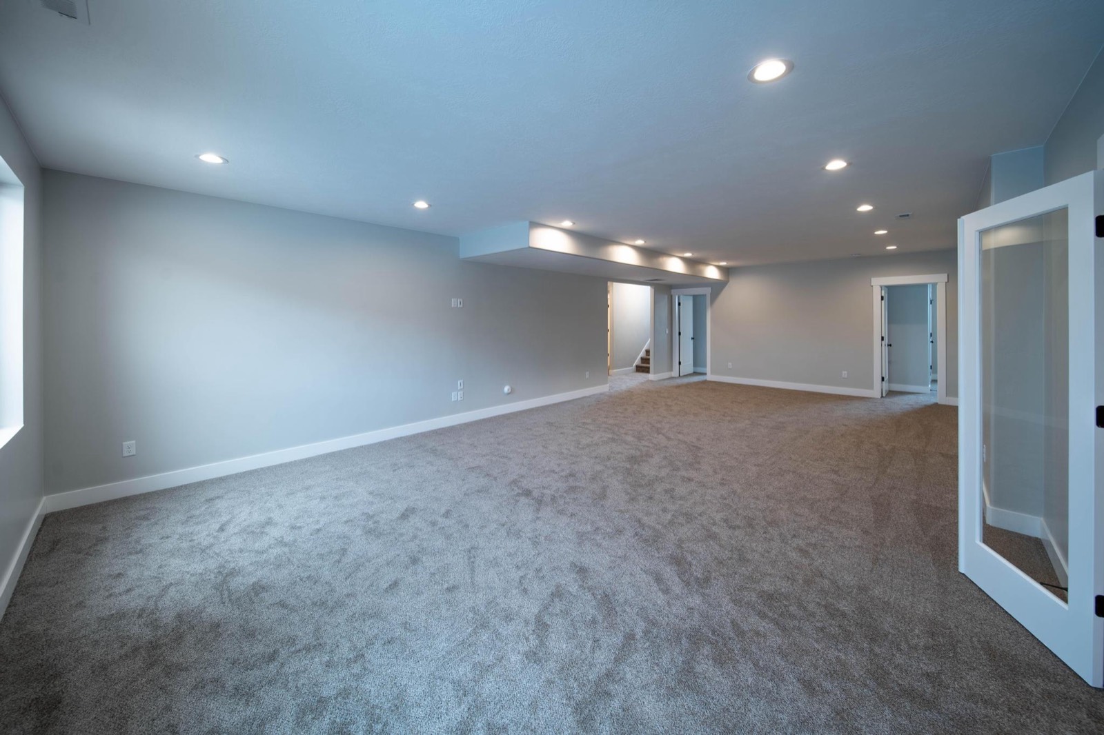 Finished basement apartment space with fresh drywall, trim, and carpet
