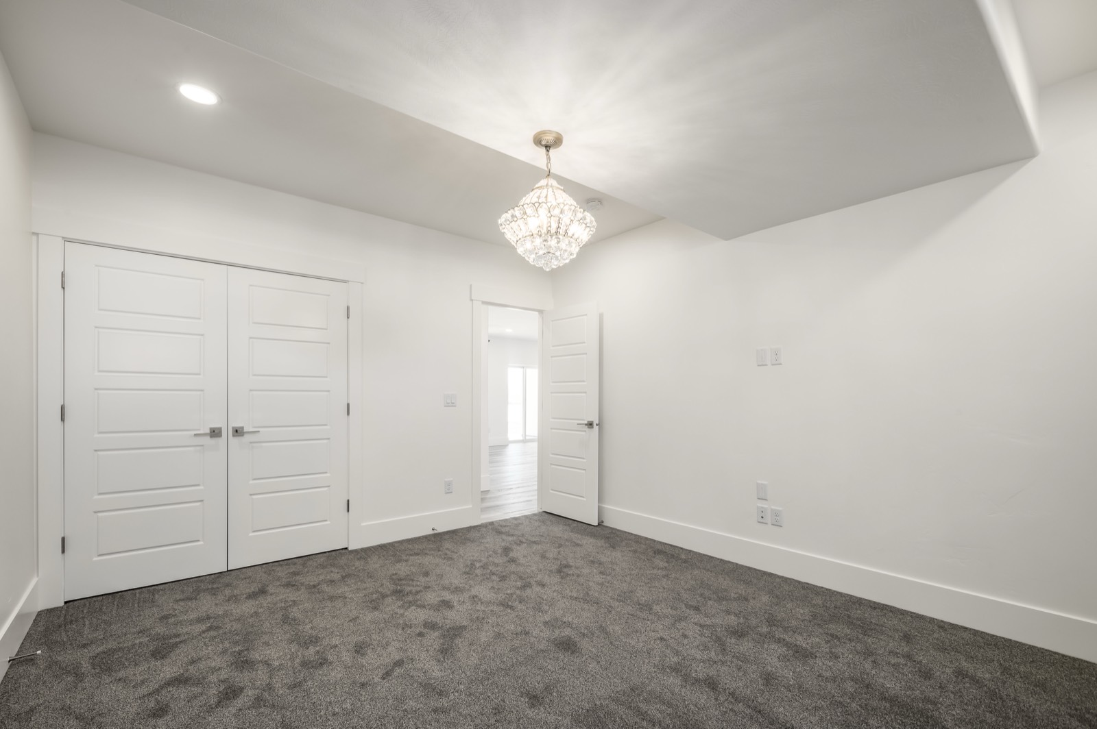 Basement apartment bedroom with fresh white walls and plush carpet