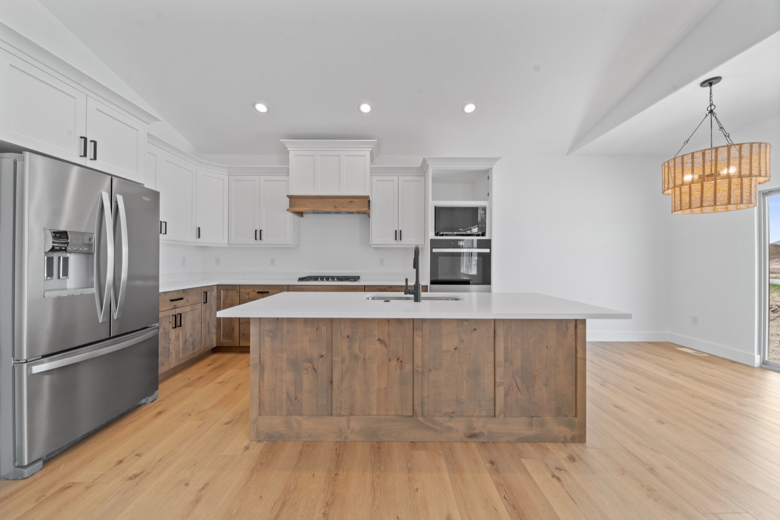 Remodeled kitchen with stained alder cabinets and a quartz island